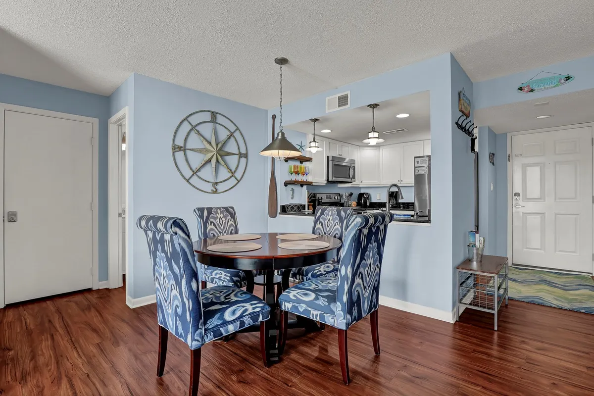 A warm and stylish dining area with a dining table surrounded by colorful chairs, decorative starfish accents, and an inviting kitchen entrance, ideal for casual family meals or gatherings.