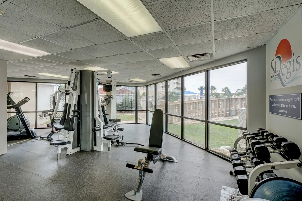 A naturally lit fitness center outfitted with modern exercise equipment and large windows. The space looks energetic and motivational, encouraging visitors to focus on their wellness and fitness routines.
